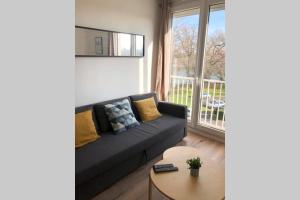 a living room with a couch and a table at Le Sweet Toulouse Purpan - Hopital & Tram à 5 minutes - Parking in Toulouse