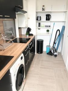 a kitchen with a washer and dryer in it at Le Sweet Toulouse Purpan - Hopital & Tram à 5 minutes - Parking in Toulouse