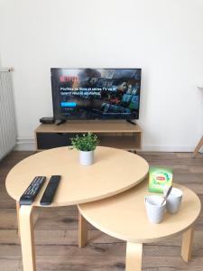 a coffee table with a remote control and a tv at Le Sweet Toulouse Purpan - Hopital & Tram à 5 minutes - Parking in Toulouse