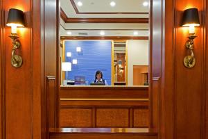 a woman is reflected in a mirror at Rockville Centre Hotel - JFK Airport in Lynbrook