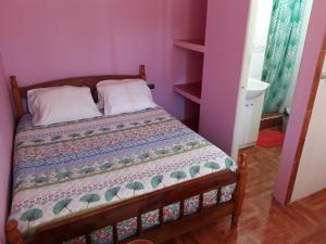 um quarto com uma cama num quarto cor-de-rosa em Hospedaje Los Abuelos em Pichilemu