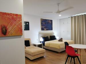 a bedroom with a bed and a table and a couch at Apple Home 2 at Menara Simfoni, King Size Bed, Cheras, Nexflix, Wifi, Parking in Seri Kembangan