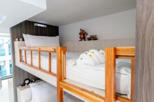 sypialnia z 2 łóżkami piętrowymi i białymi poduszkami w obiekcie The Proud Hotel Pattaya - SHA Certified w mieście Pattaya North