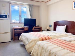 Postel nebo postele na pokoji v ubytování Hotel Peace Island Miyakojima