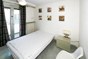 una habitación de hospital con una cama y una silla en L'Imperial, en Le Grau-du-Roi