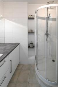 Un baño blanco con ducha y lavabo. en L'Imperial, en Le Grau-du-Roi