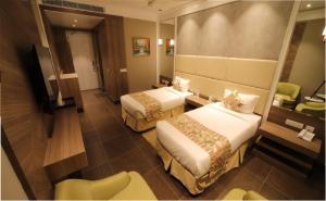 a hotel room with two beds and a television at THE GRAND VILLAGE in Morādābād