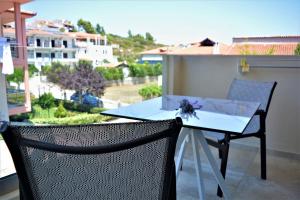 a table and chairs on a balcony with a view at The Archontariki in Ormos Panagias