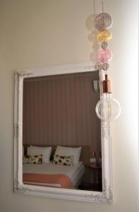 a mirror on a wall with a bed in a room at The Archontariki in Ormos Panagias