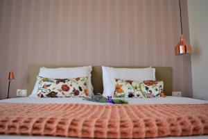 a bedroom with a bed with flowers and pillows at The Archontariki in Ormos Panagias