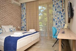 a small bedroom with a bed and a window at The Archontariki in Ormos Panagias