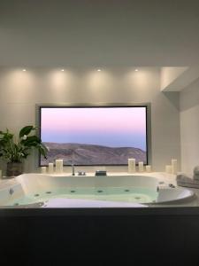y baño con bañera y ventana grande. en " ARADA " Luxury House en Arad
