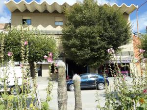een auto geparkeerd voor een gebouw met bloemen bij Crystal Hotel in La Quiaca