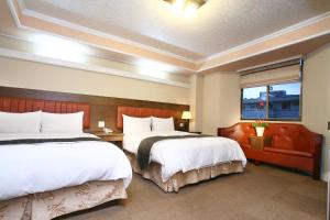 a hotel room with two beds and a window at Hefong Jaee Hotel in Jiaoxi