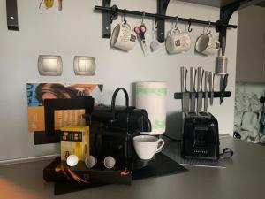 a kitchen counter with a coffee maker and coffee cups at Ingress in Bytom