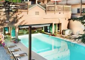 a swimming pool with chairs and a building at GetAways at Eagle Point Resort in Vail