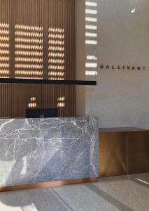 a marble counter in a lobby with a sign on the wall at The Gallivant Hotel in George Town