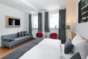 une chambre avec un lit, un canapé et une télévision dans l'établissement Am Landhof Ferienwohnung, à Heilbad Heiligenstadt