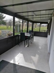 a screened in porch with a table and chairs at Gîtes aux cœurs des vignes a 10mm du zoo de beauval 3 étoiles in Mareuil-sur-Cher