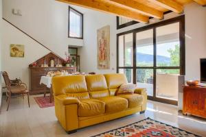 Carmen de Nella Eco Lodge 4* في كابرينو فيرونيسي: غرفة معيشة مع أريكة صفراء وطاولة