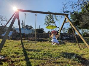 a little girl sitting on a swing at Hakuna matata in Benagil