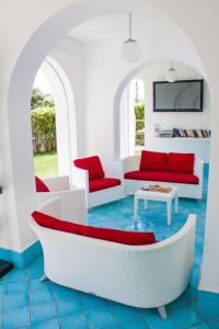 a living room with red and white furniture at Ganimede Hotel in Sperlonga