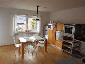 cocina con mesa, sillas y ventana en SHERPA HAUS Ferienwohnung am Hahnenkamm,Reutte en Hofen