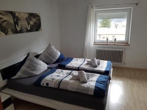 1 dormitorio con 2 camas con almohadas y ventana en SHERPA HAUS Ferienwohnung am Hahnenkamm,Reutte en Hofen