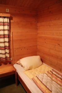 uma pequena cama num quarto de madeira com uma janela em Landhaus mit Saunakeller em Bad Wünnenberg