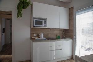 a kitchen with white cabinets and a microwave at Casalina in Lido di Jesolo