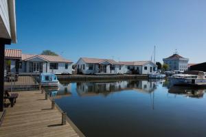 een jachthaven met huizen en boten in het water bij Swift Cottage, Norfolk Broads in Potter Heigham