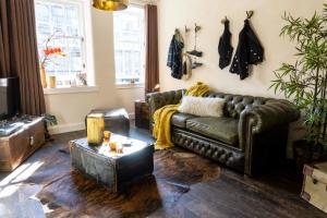 a living room with a leather couch and a table at Grassmarket Old Town Boutique Apartment in Edinburgh