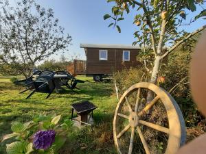 een groep picknicktafels en een tiny house bij Roulotte Bigoudenne in Tréméoc