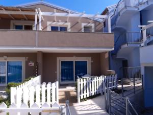 a house with a white fence in front of it at CASA VACANZE PAOLA SARDEGNA in Viddalba