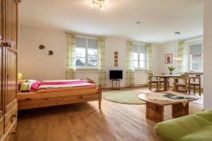 a living room with a bed and a dining room at Ferienwohnung am Schloss in Heiligenberg