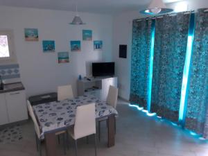 a dining room with a table and chairs and a television at CASA VACANZE PAOLA SARDEGNA in Viddalba