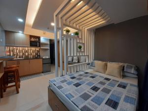 a bedroom with a large bed and a kitchen at 1Tagaytay in Lipa