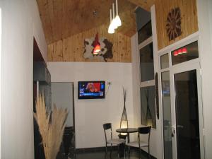 Una habitación con una mesa y un televisor en la pared. en Hosteria Kaiken Gregores, en Gobernador Gregores
