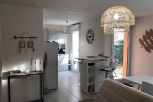 uma cozinha e sala de estar com uma mesa e um sofá em Appartement cosy avec jardin à Blagnac. em Blagnac