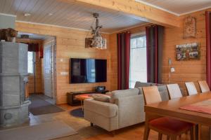 a living room with a couch and a television and a table at Villa Saaruanniemi B in Ruka