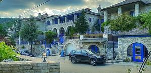a car parked in front of a large house at Archontiko Zarkada in Monodendri