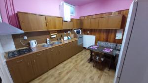 a kitchen with wooden cabinets and a table in it at Brasov - Centrul Vechi in Braşov