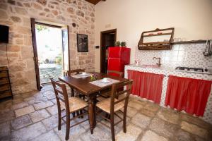 een keuken met een houten tafel en een rode koelkast bij IzzHome Carrubo in Santa Croce Camerina