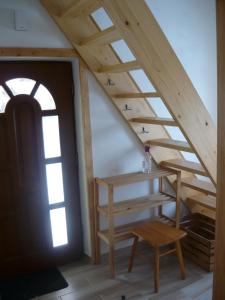 an attic room with a wooden staircase and a table at Wichrowe Wzgórze in Dynów