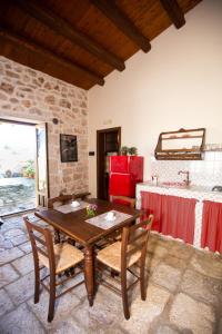 een eetkamer met een houten tafel en stoelen bij IzzHome Carrubo in Santa Croce Camerina