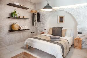 1 dormitorio con cama y pared de piedra en 11 - LA GUARIDA DE TARIFA - Segundo A - ENJOY TARIFA, en Tarifa