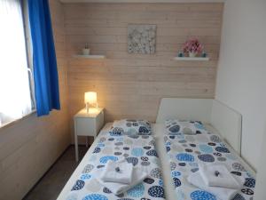 a bedroom with a bed with blue and white sheets at Apartment Moravský Kras in Rájec-Jestřebí