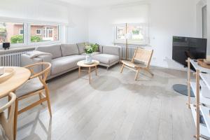 ein Wohnzimmer mit einem Sofa und Stühlen in der Unterkunft Haus Ferienglück in Norderney
