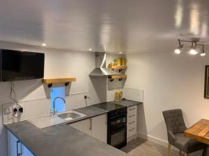 a kitchen with a sink and a counter top at Delightful One Bed Lake District Cottage in Penrith