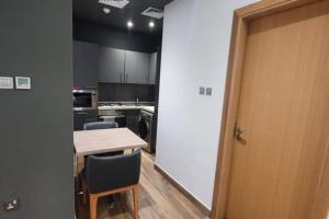 a kitchen with a table and chairs and a door at Metro Access Cozy Furnished Studio at JBR walk in Dubai